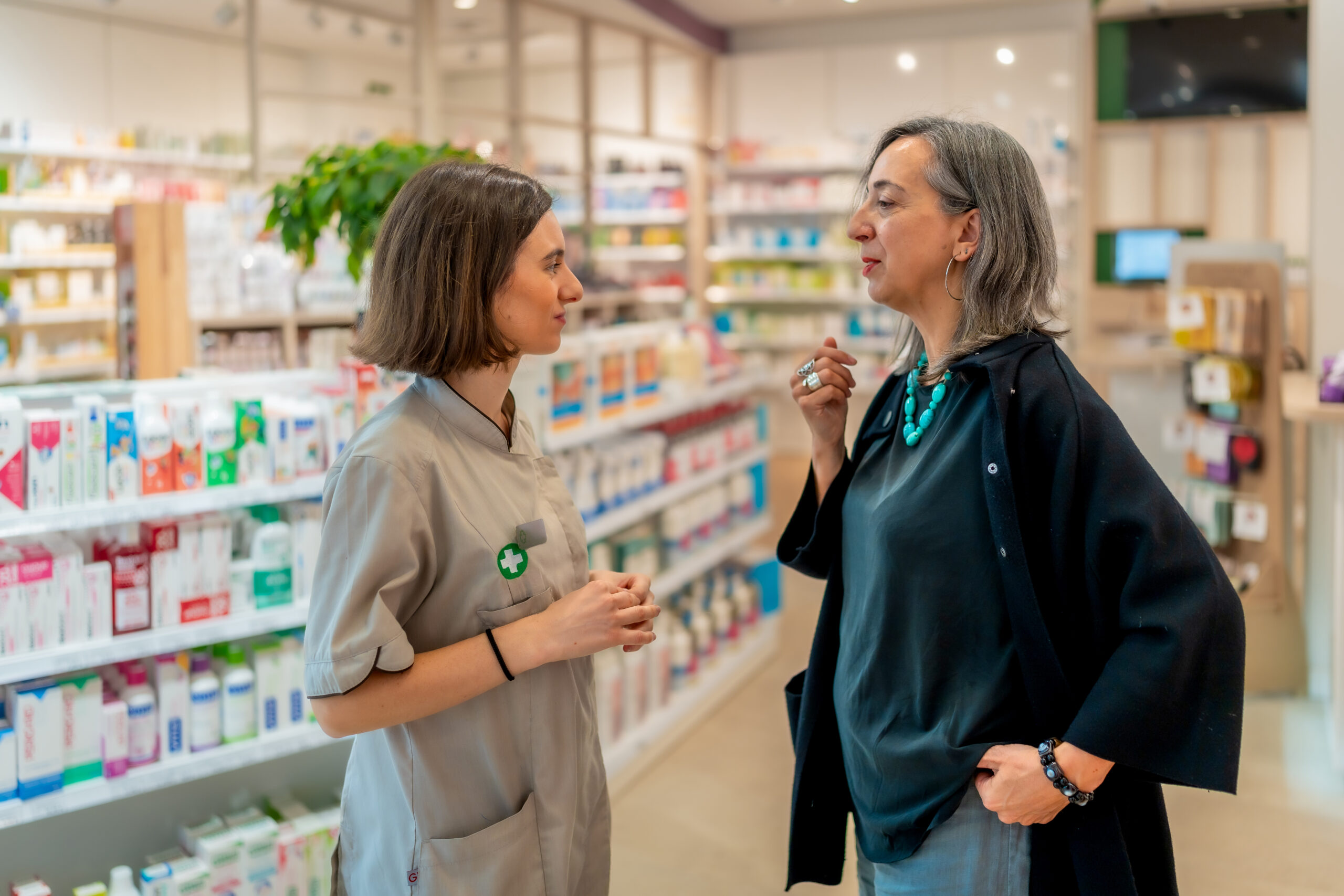 Pharmacist and woman standing in the store talking