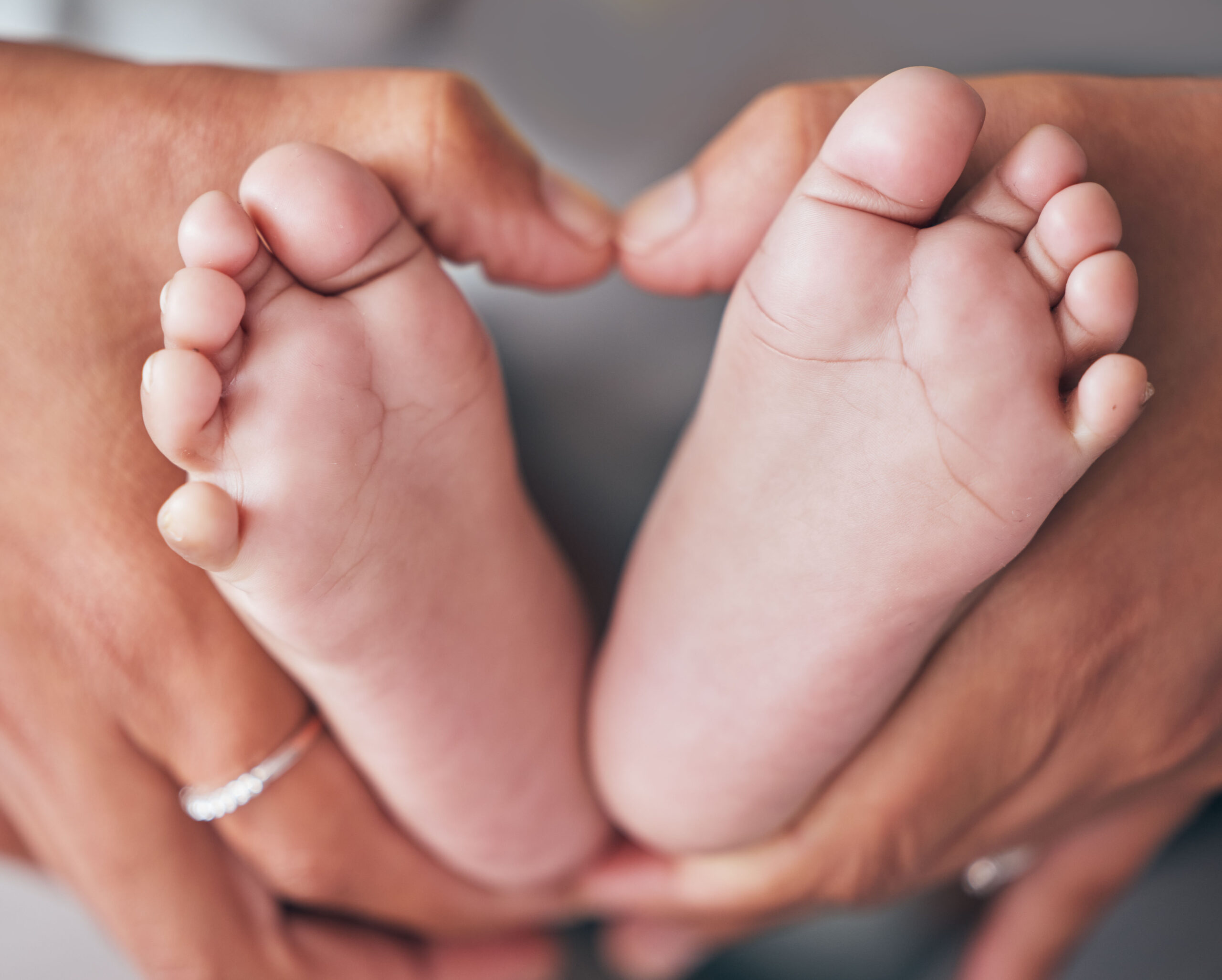 baby-feet-and-hands-of-mother-closeup-with-newbor-2025-04-06-09-00-36-utc