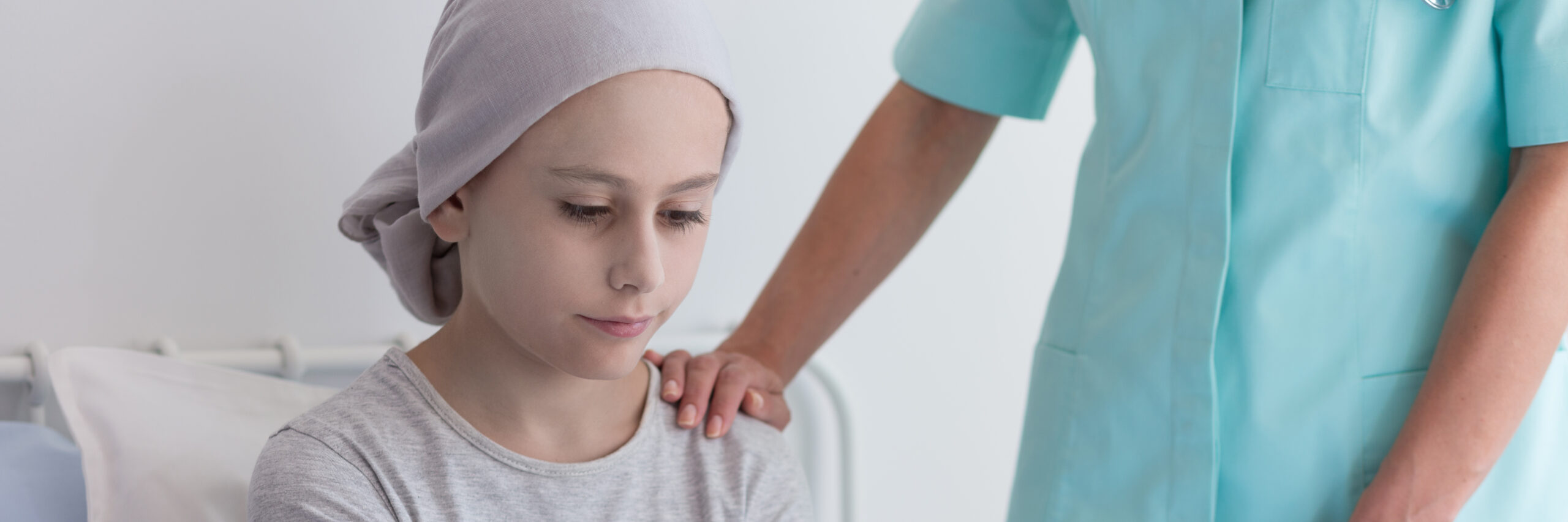 Panorama of nurse helping sick kid with cancer wearing pink head