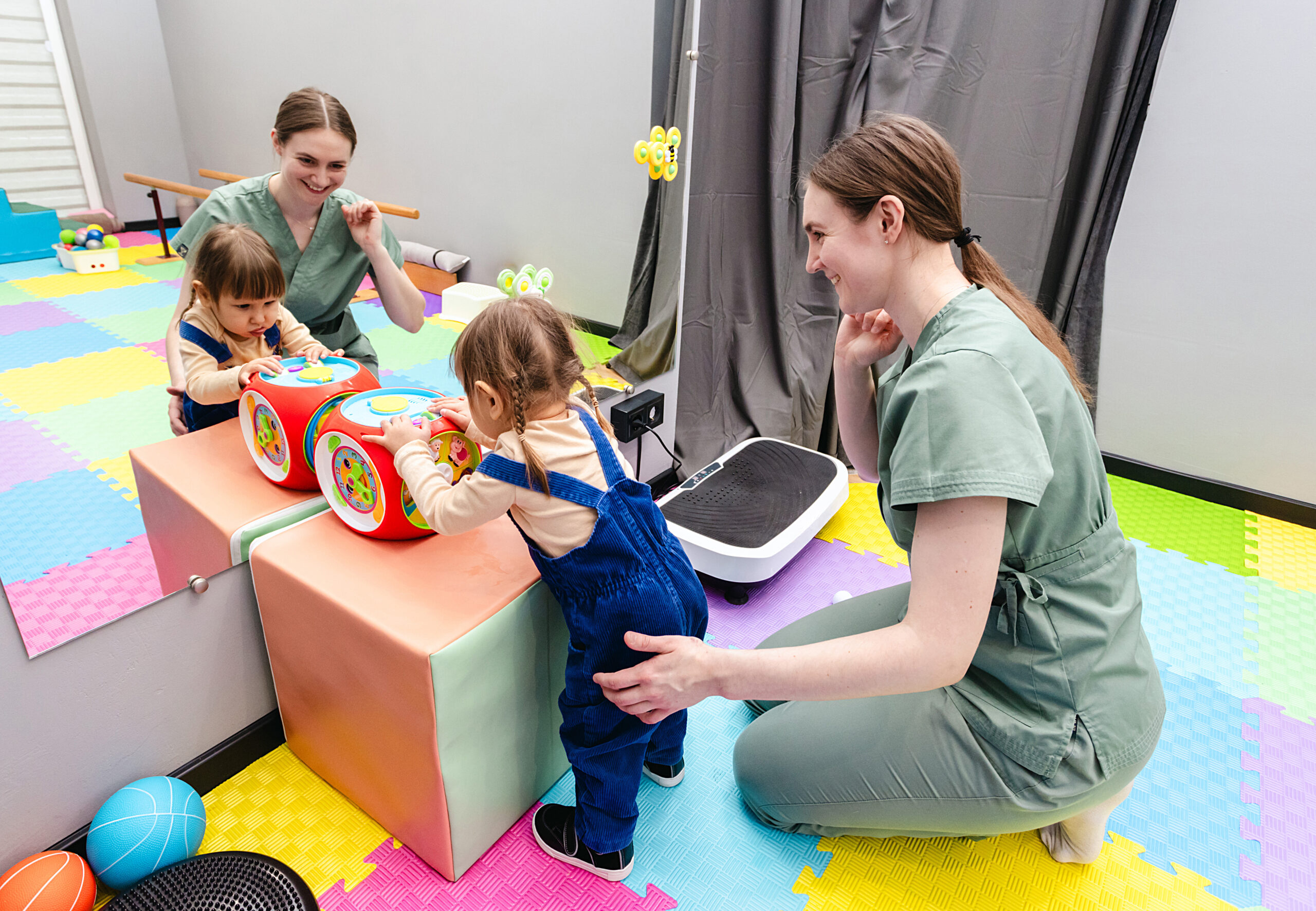 Physiotherapist assists a young girl with cerebral palsy during his rehabilitation exercises in a vibrant therapy room