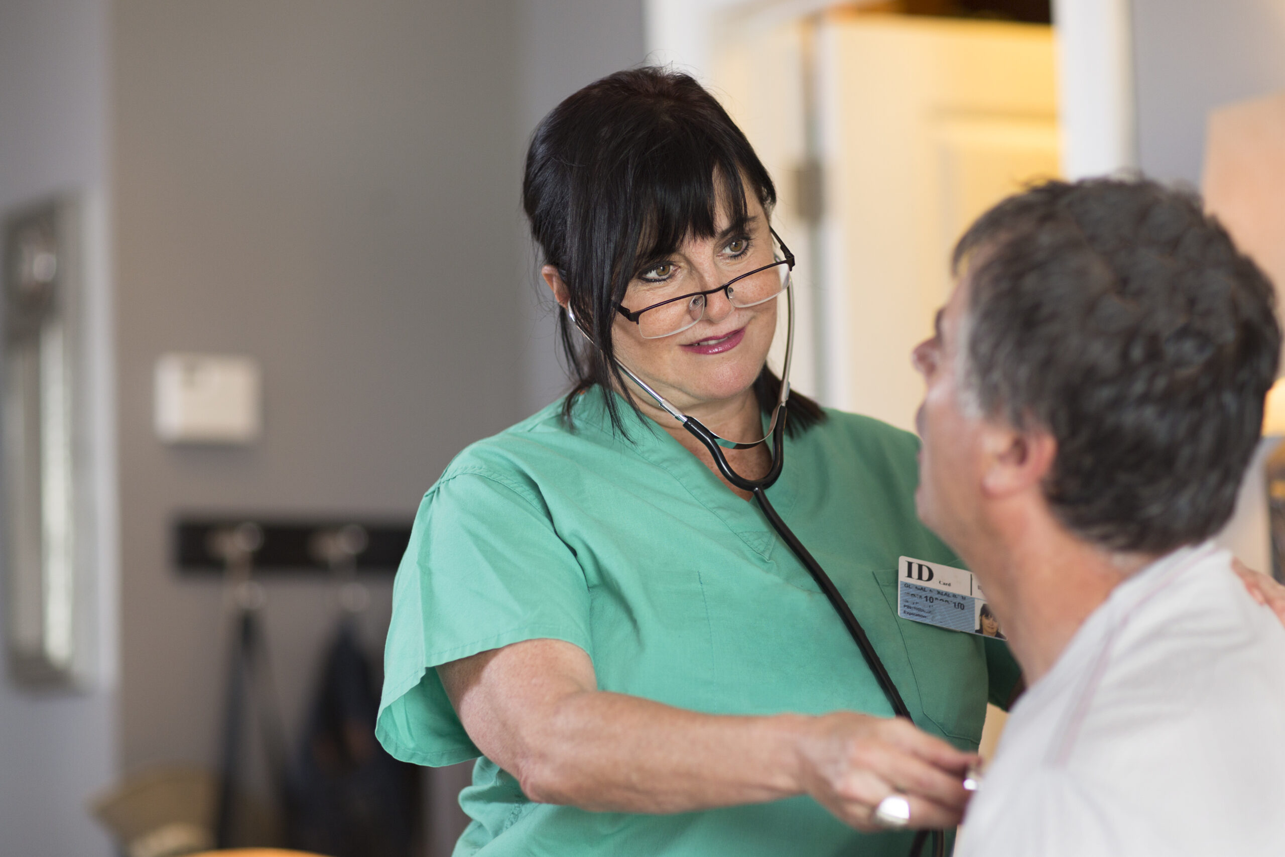 Senior female nurse checking patient's heart