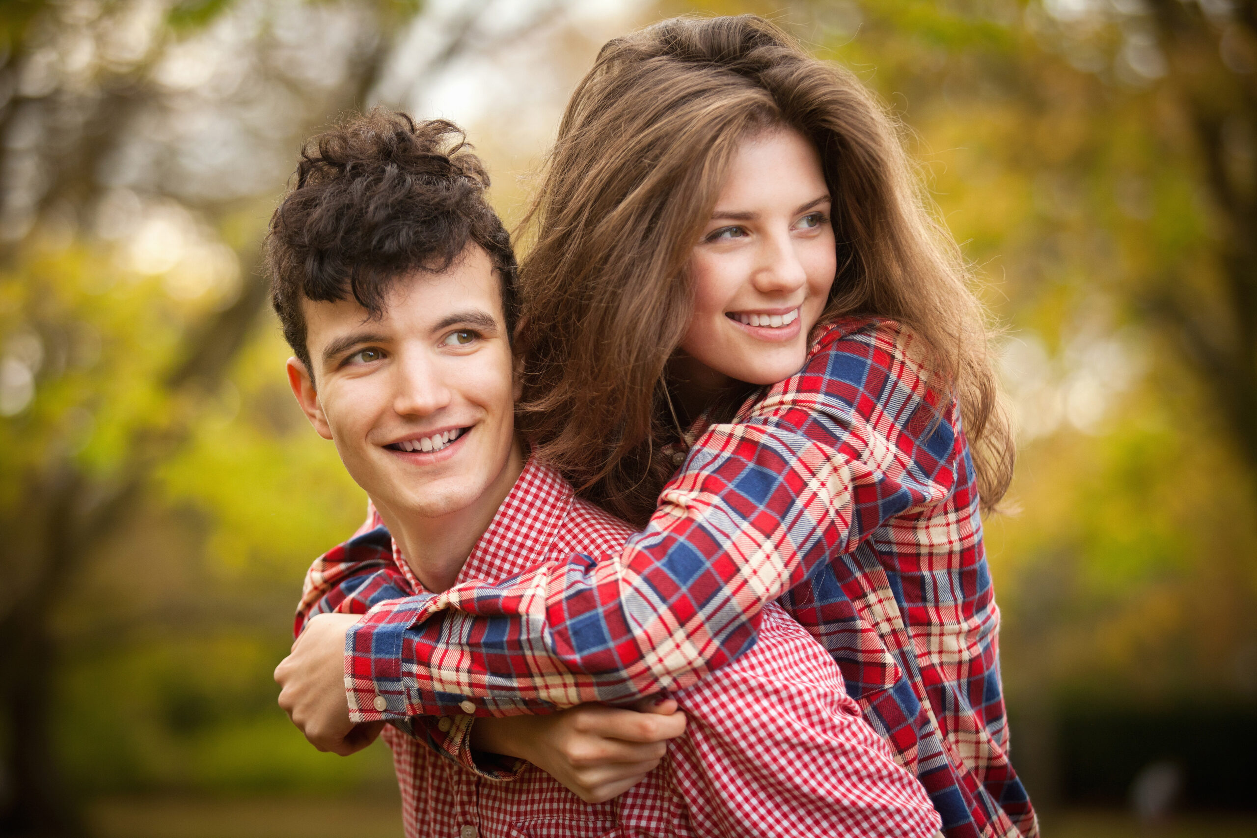 Teenage couple hugging in park