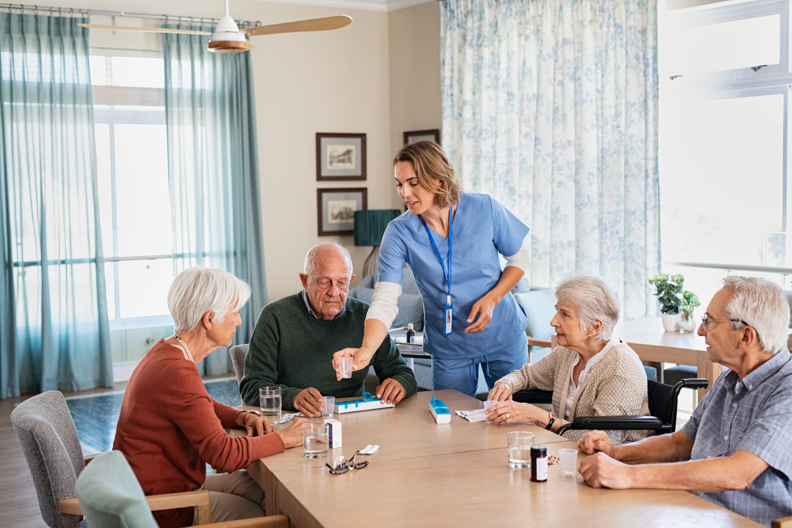 Nurse giving daily medicine to seniors at nursing home