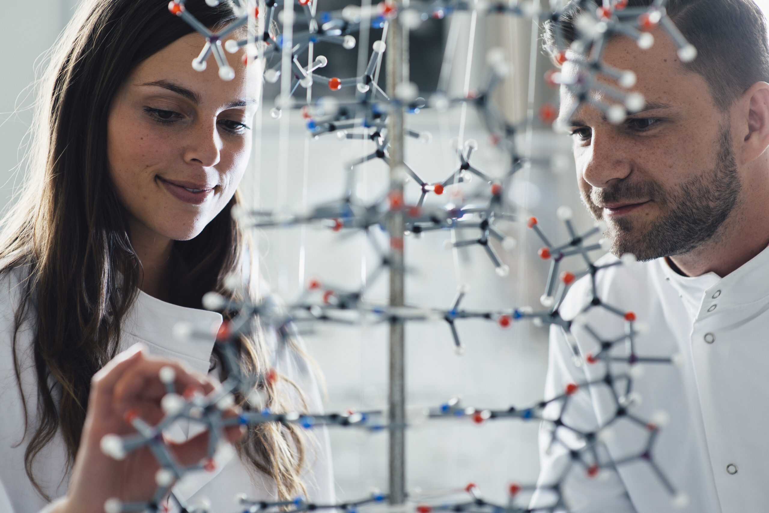 Two scientists examining a molecular model in a lab.