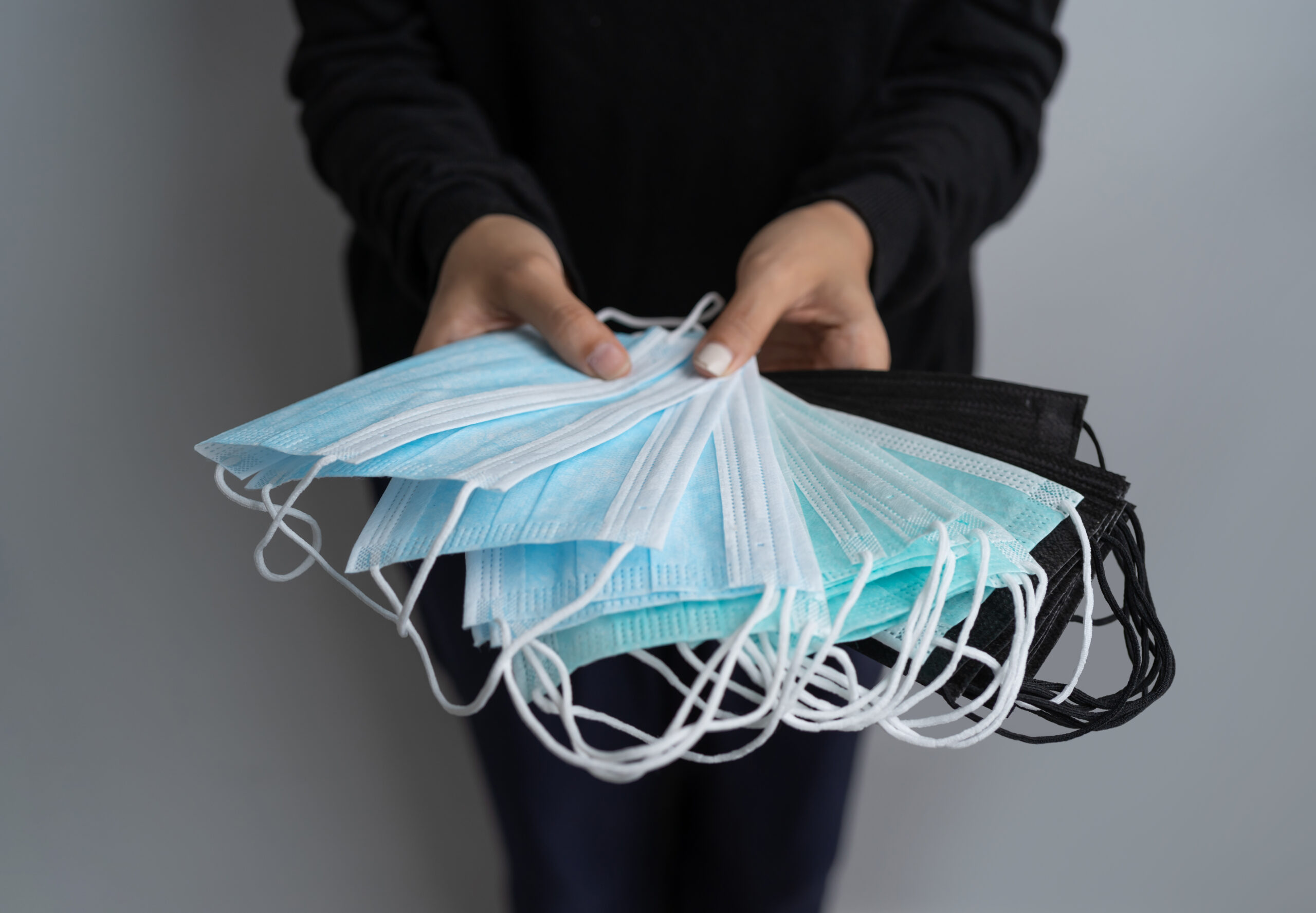 Hands hold face mask isolated on white background. Face covering. Virus protection. Medical and healthcare. Coronavirus covid-19 outbreak.