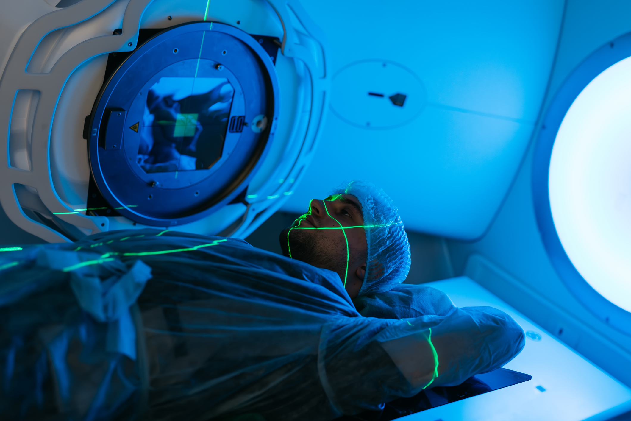 A young man undergoing radiation therapy for cancer in a state-of-the-art oncology clinic using a linear accelerator.