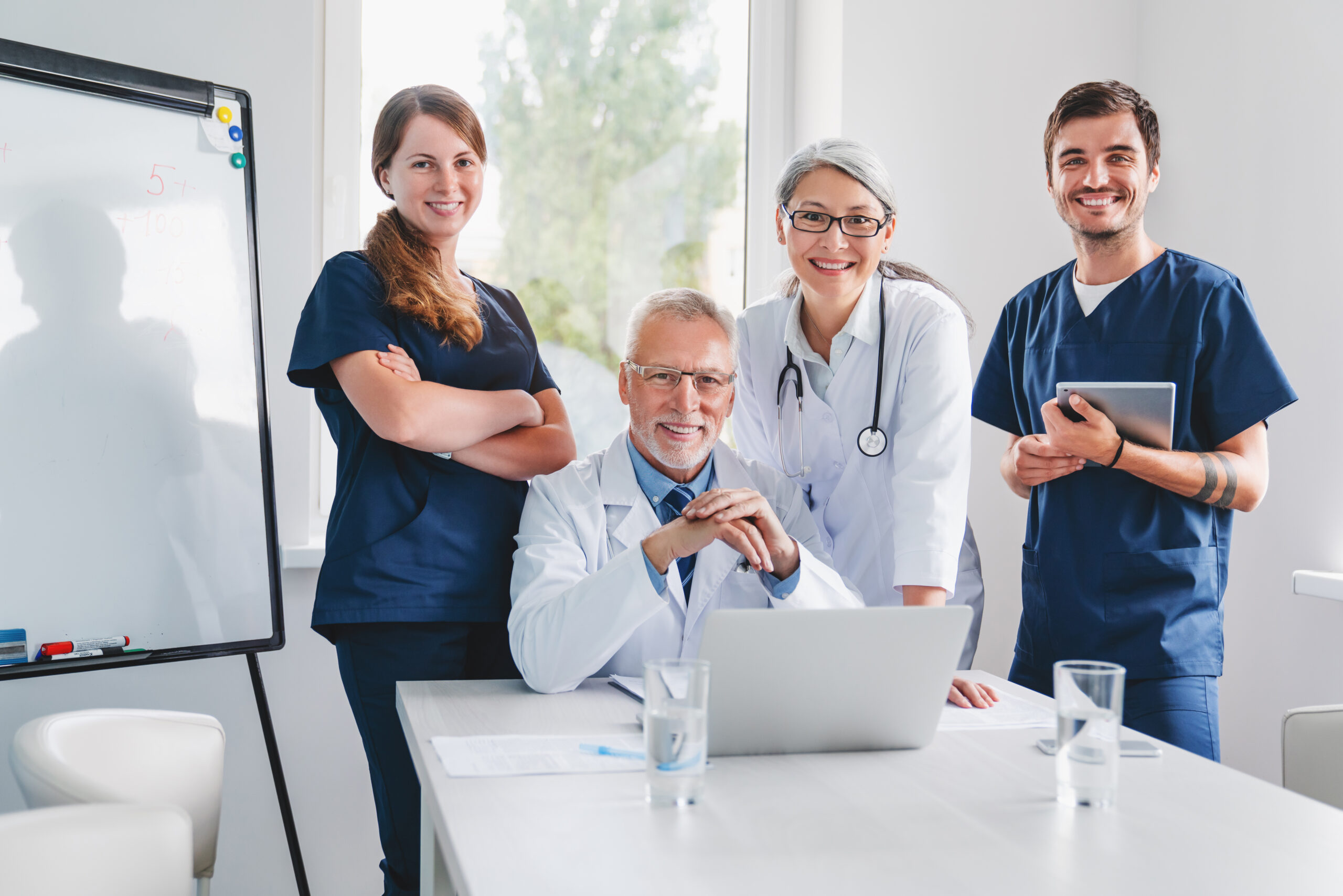 Portrait of smiling medical team near desk in hospital office