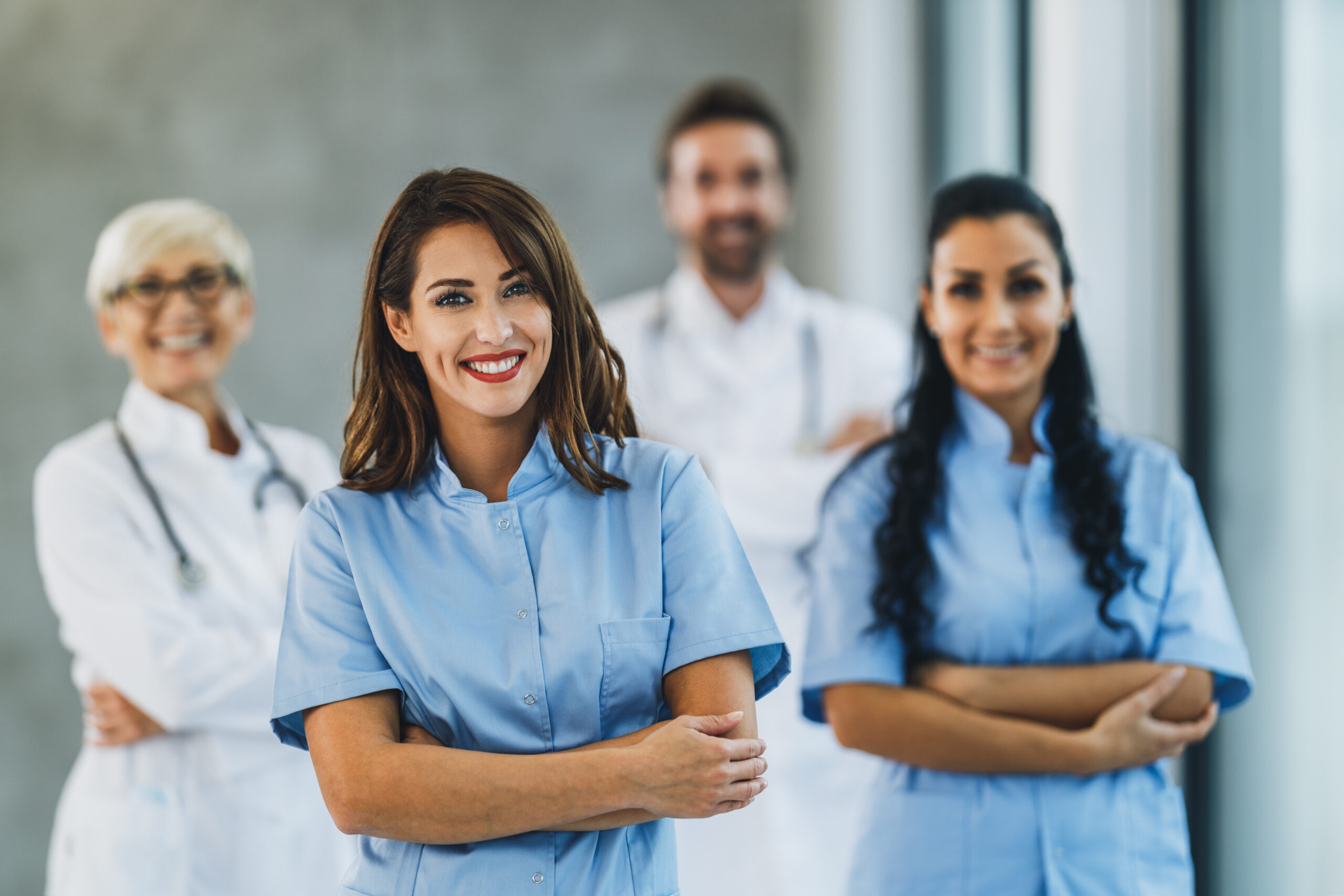 Medical Team Of Nurses And Doctors Standing With Arms Crossed And Looks At Camera