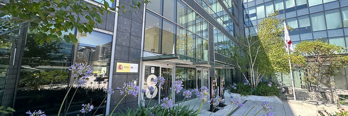 Edificio de la AEMPS con flores en primer plano y banderas