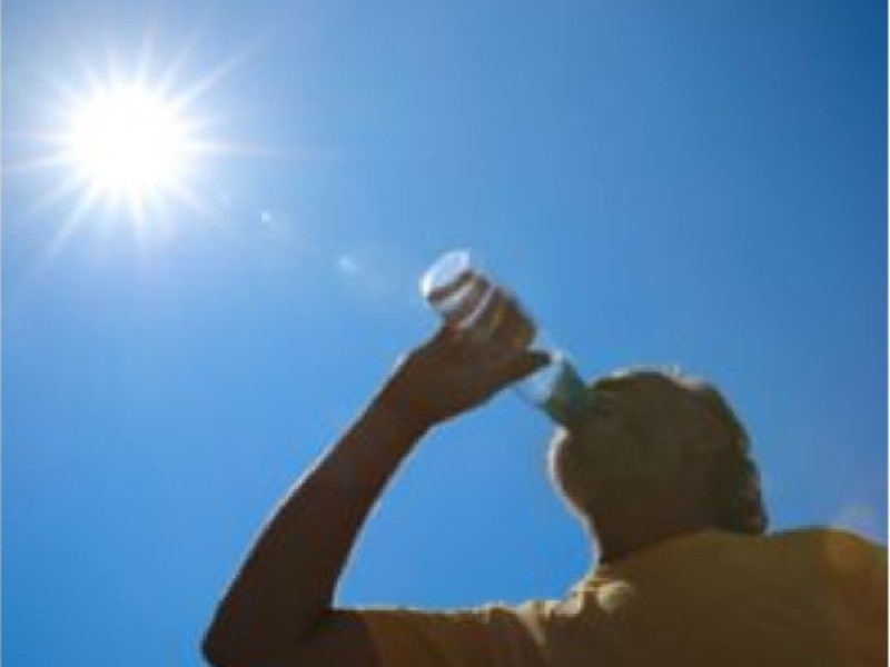 Persona bebiendo agua bajo el sol intenso