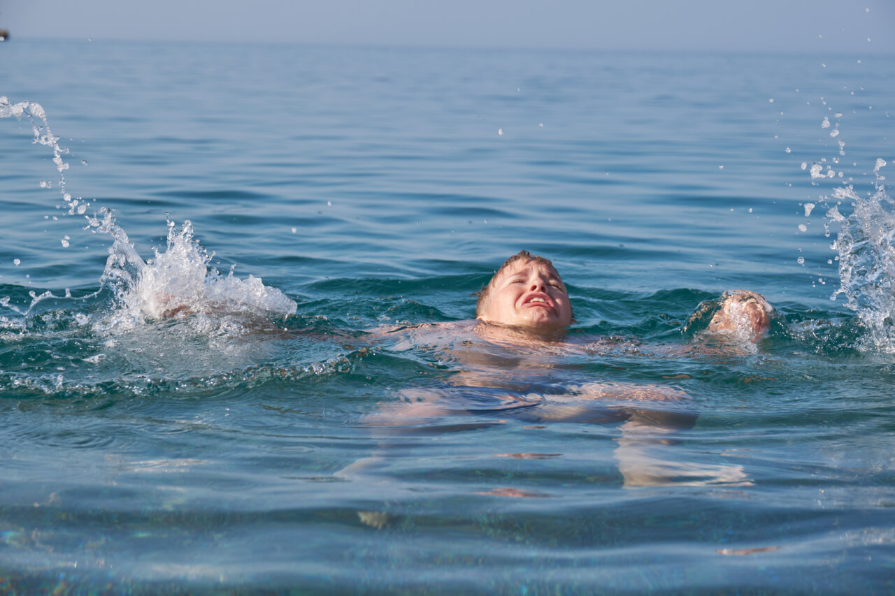 Un niño luchando por mantenerse a flote en el mar