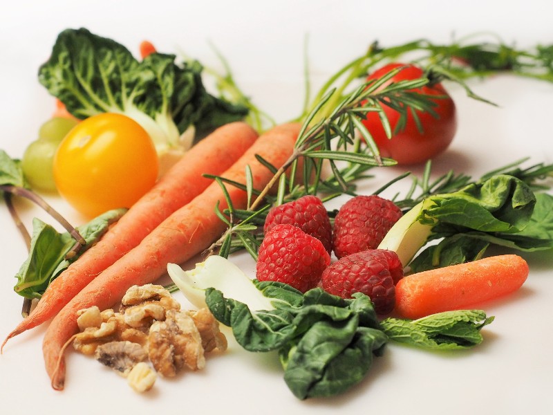 Variedad de verduras y frutas frescas sobre una superficie blanca