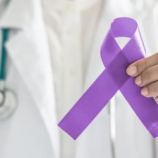 Revisión de medicamento para cáncer de páncreas Médico sosteniendo un lazo morado en apoyo al cáncer de páncreas